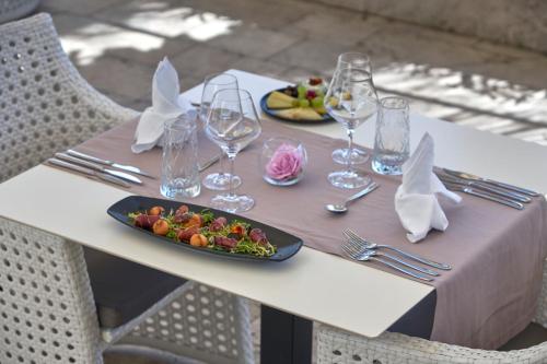 a table with two plates of food and wine glasses at Boutique Hotel Life in Rogoznica