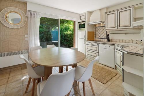 - une cuisine avec une table en bois et des chaises blanches dans l'établissement Cazet Cozy - 2BR 6P - Estate with Pool Gassin, à Saint-Tropez