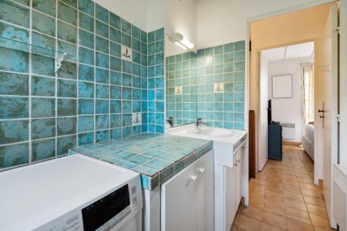 La cuisine est dotée de carrelage bleu sur le mur et d'un évier. dans l'établissement Cazet Cozy - 2BR 6P - Estate with Pool Gassin, à Saint-Tropez