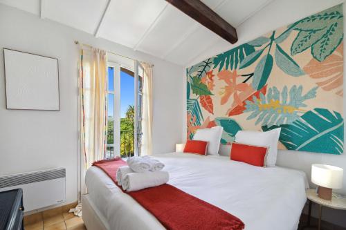 - une chambre avec un lit blanc et une fresque murale dans l'établissement Cazet Cozy - 2BR 6P - Estate with Pool Gassin, à Saint-Tropez