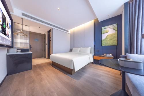 a hotel room with a bed and a desk and a sink at Atour Hotel Chengdu Sichuan University North Kehua Road in Chengdu