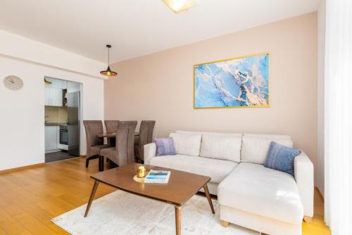 a living room with a white couch and a table at Apart hotel M S KATUNJANIN in Herceg-Novi