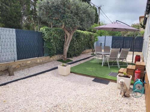 - un petit jardin avec une table et un parasol dans l'établissement Mobil home de Patricia et Franck à Sigean, à Sigean