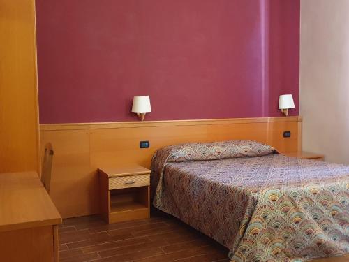 a bedroom with a bed and two lamps on the wall at Beauty Rooms in Rome