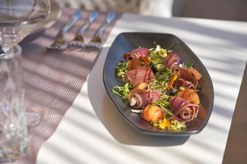 a black plate of food on a table at Boutique Hotel Life in Rogoznica
