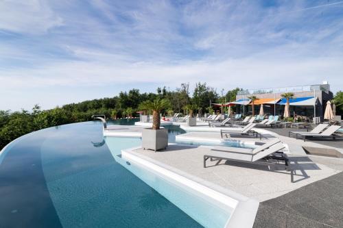 duży basen z leżakami i ośrodek w obiekcie Hotel Ózon & Luxury Villas w mieście Mátraháza