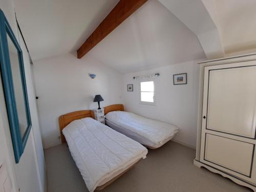 deux lits dans une petite pièce avec une fenêtre dans l'établissement Charmante maison près du golf et plage avec terrasse et parking - FR-1-323-514, à Saint-Jean-de-Monts
