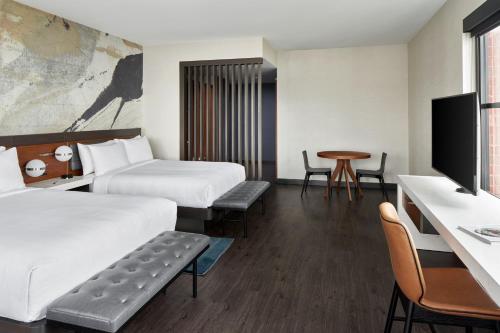 a hotel room with two beds and a table at Marriott Owings Mills Metro Centre in Owings Mills