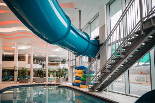 a slide in a building with a pool at Hotel Ózon & Luxury Villas in Mátraháza