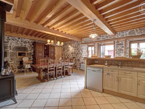 une cuisine avec une table et une salle à manger dans l'établissement Gîte charmant avec cheminée, terrasse, et jardin privé à Saint-Just-en-Bas - FR-1-496-19, à Saint-Just-en-Bas