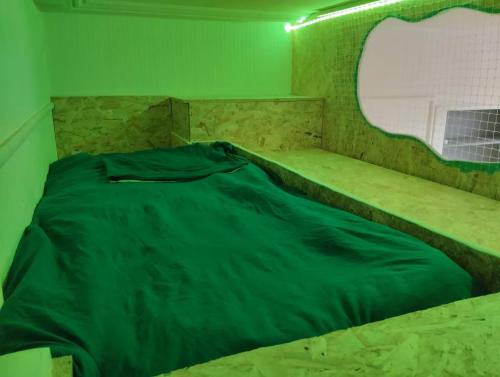 a bed in a room with a green wall at Studio Chapelle in Dunkerque