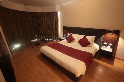 a bedroom with a large bed with red pillows at Monteverde Hotel in Beit Meri
