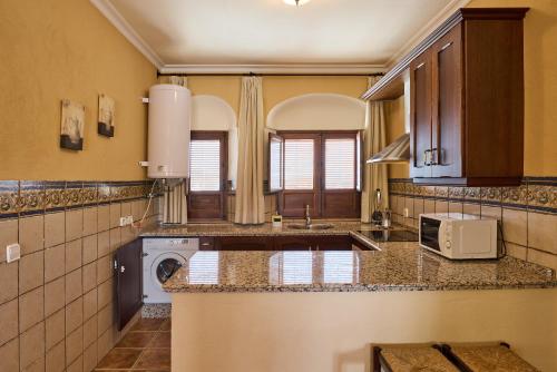una grande cucina con lavatrice e asciugatrice di Apartamentos Valsequillo Córdoba a Valsequillo