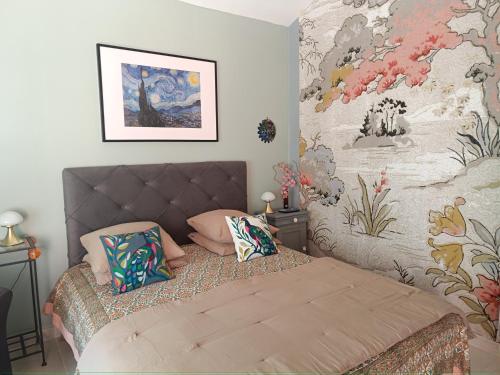 una camera da letto con un letto con cuscini di Entre vignes & Piano "Caudalie" chambre d'hôtes a La Roque-dʼAnthéron