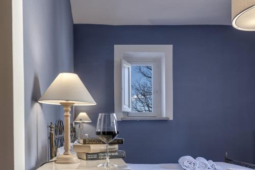 a blue room with a table with a lamp and a window at Agriturismo La Fattoria di Capezzana in Carmignano