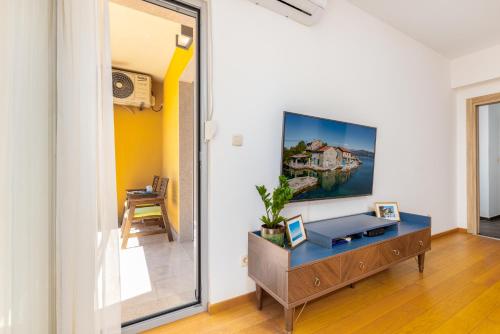a living room with a table and a mirror at Apart hotel M S KATUNJANIN in Herceg-Novi
