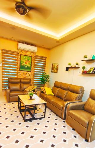 a living room with a couch and a table at Homestay Bunga Kertas Jitra in Jitra