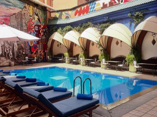 a swimming pool with chaise lounge chairs next to a building at Blue Sea Le Printemps in Marrakech