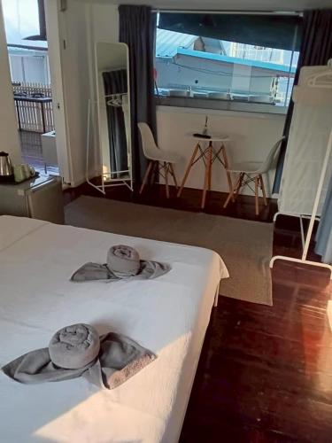 a bedroom with a bed with two hats on it at Aran hostel Spa&Cafe Riverside That Phanom in Amphoe That Phanom