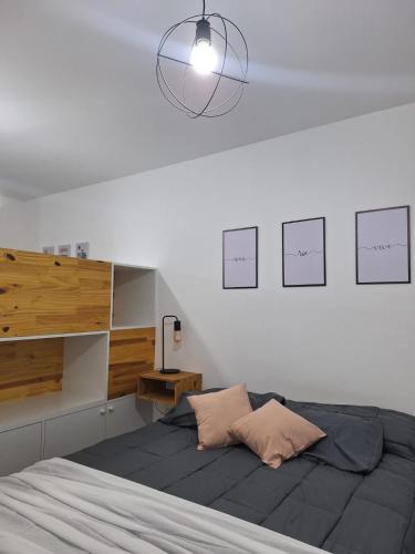 a bedroom with a bed and some drawings on the wall at Amoblado Carlos I in Río Cuarto