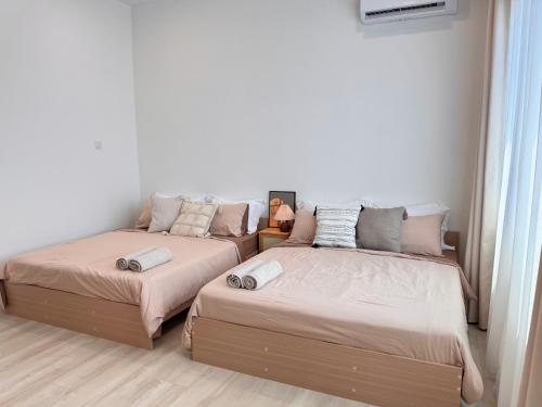 two beds sitting next to each other in a room at MokuMoku Miri Homestay FOC Netflix & Ytb 18pax in Miri