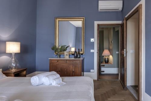 a blue bedroom with a bed and a mirror at Agriturismo La Fattoria di Capezzana in Carmignano