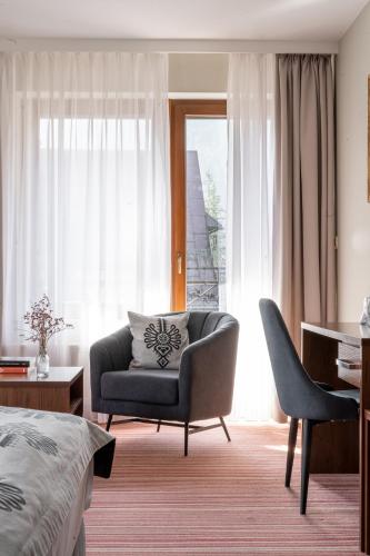 a bedroom with a chair and a desk and a bed at Hotel Willa Pod Skocznią in Zakopane