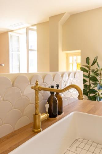 un évier avec un robinet et deux bouteilles dans l'établissement Le charme de l'ancien, rénové - Nice - 4 personnes, à Nice