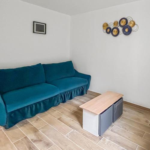 un salon avec un canapé bleu et une table dans l'établissement Confort & calme proche Marne, à Champigny-sur-Marne
