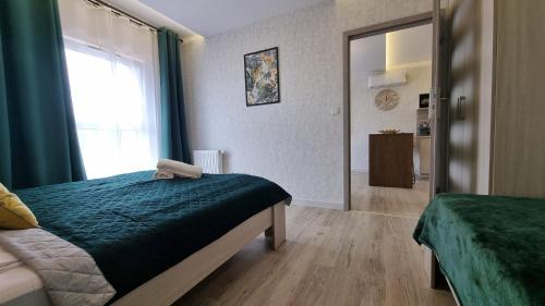 a bedroom with a bed and a large window at Q Apart PL 2 lub 3 pokojowe klimatyzowane apartamenty przy Manufakturze z garażem Gratis, FV in Łódź