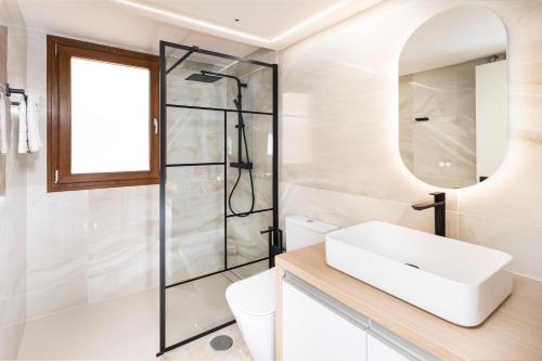 a white bathroom with a sink and a shower at CC8 III by ZANIS in Torrevieja