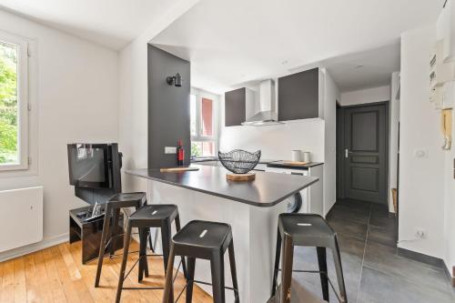 Una cocina con encimera y taburetes en una habitación. en T3 Appartement au centre ville, en Annecy