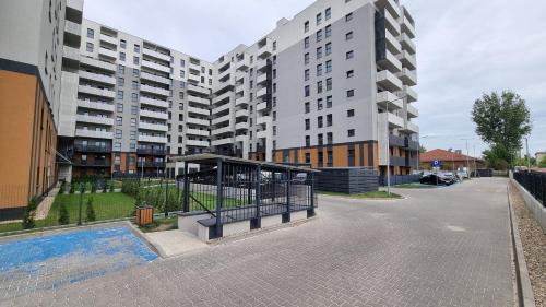 an empty street with two tall apartment buildings at Q Apart PL 2 lub 3 pokojowe klimatyzowane apartamenty przy Manufakturze z garażem Gratis, FV in Łódź