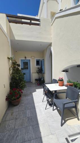a patio with a table and chairs on a patio at Villa Roussa City Center in Fira