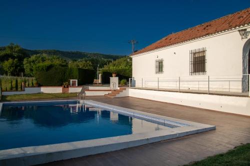 a house with a swimming pool next to a building at Casa de campo "La Campanera" in Constantina