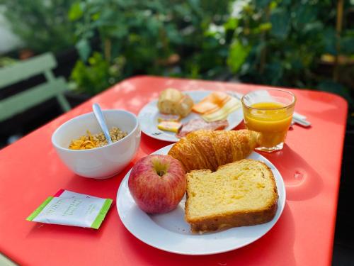 a red table with two plates of food and an apple and toast at The People - Paris Bercy in Paris