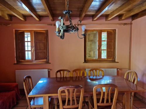 a dining room with a wooden table and chairs at La Cerezal I in Borines