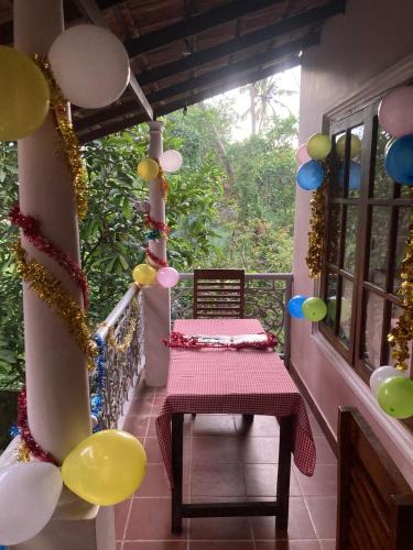 a porch with a bench and balloons on a balcony at Mandaram villas in Mararikulam