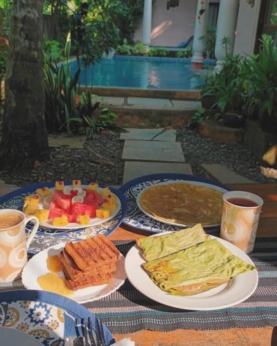 a table with plates of breakfast food on it at Mandaram villas in Mararikulam