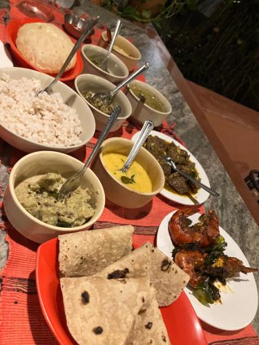 a table topped with bowls of different types of food at Mandaram villas in Mararikulam