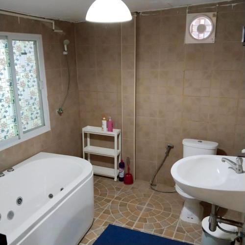 a bathroom with a tub and a toilet and a sink at Aran hostel Spa&Cafe Riverside That Phanom in Amphoe That Phanom