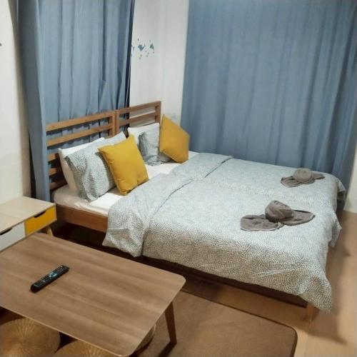 a bedroom with a bed with yellow pillows and a table at Aran hostel Spa&Cafe Riverside That Phanom in Amphoe That Phanom