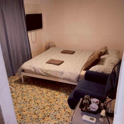 a small bedroom with a bed and a chair at Aran hostel Spa&Cafe Riverside That Phanom in Amphoe That Phanom