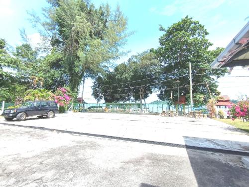 a black car parked in a parking lot at Analisa Beach Resort in Pangkor