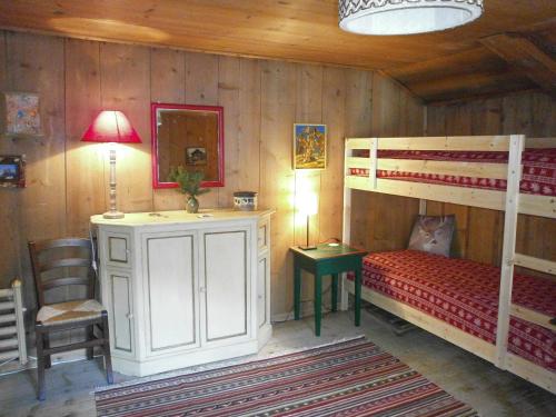 a bedroom with two bunk beds and a desk and a table at Ancient Engadine Mill in Scuol