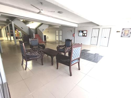 a room with chairs and a table in a building at Analisa Beach Resort in Pangkor