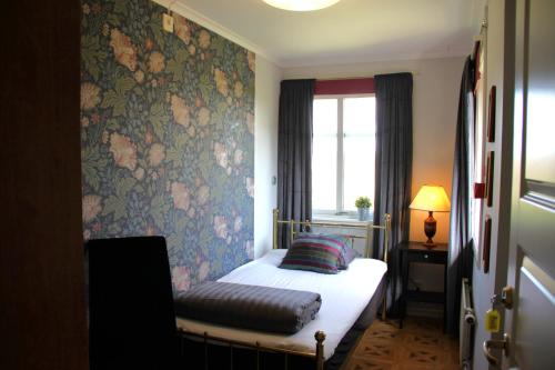 a bedroom with a bed with a floral wallpaper at Älgbergets Bed & Breakfast in Ucklum