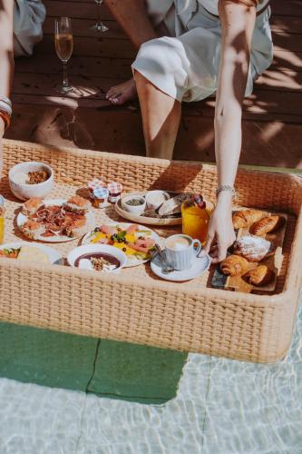 a tray of food on a table in the water at Nativo Hotel Ibiza in Santa Eularia des Riu