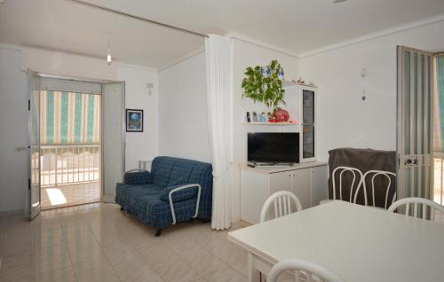 a living room with a blue chair and a television at Gorgeous Home In Finaiti, Santa Croce C in Villaggio Azzurro