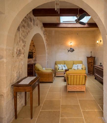 a living room with two couches and an archway at Mohba Townhouse, Private Roof Top Jacuzzi, Garden, BBQ by Haven & Keys Malta in Xagħra